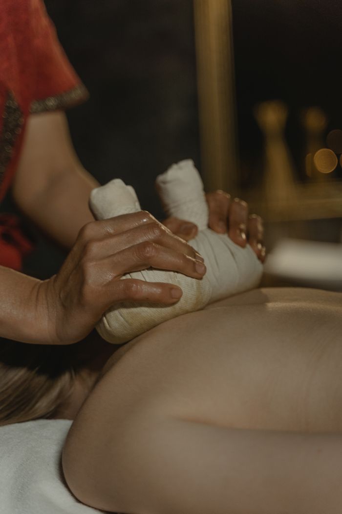 The Art of Drawing Readers In: Your attractive post title goes here Close-up of a woman receiving a relaxing herbal massage therapy session with selective focus.