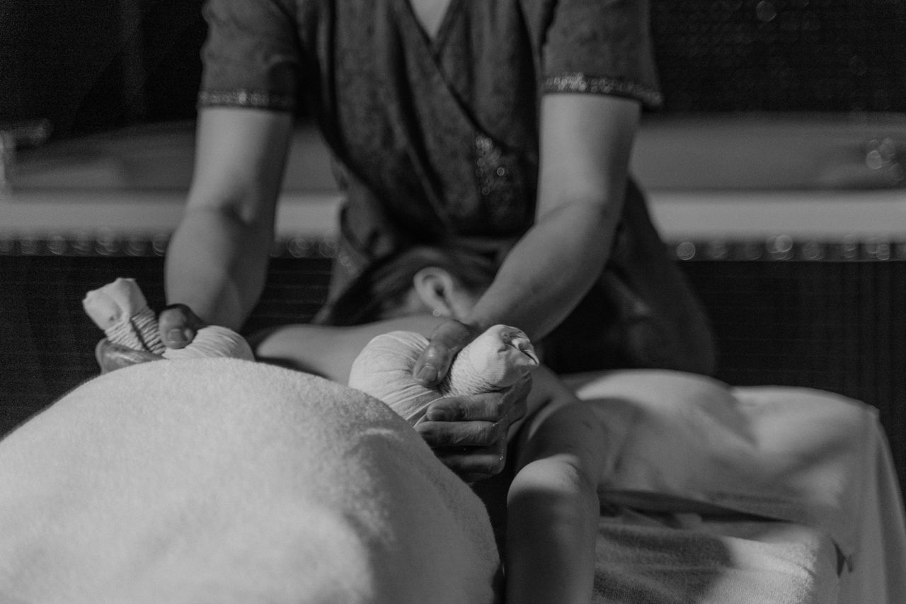 gallery-6 Black and white photo showing a relaxing outdoor massage therapy session in progress, emphasizing tranquility.